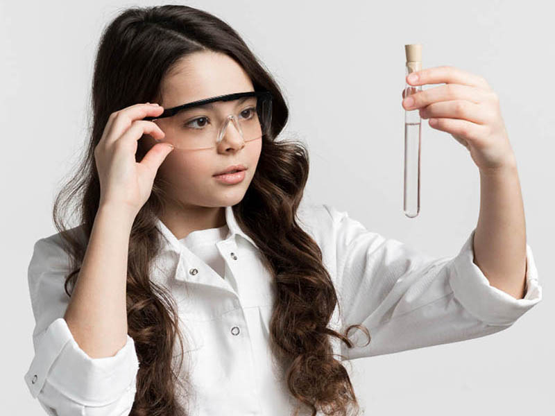 a girl scientist having a look at a test tube