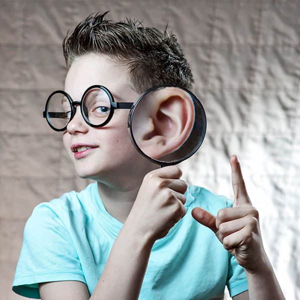 a smartly looking boy holding his magnifying glass